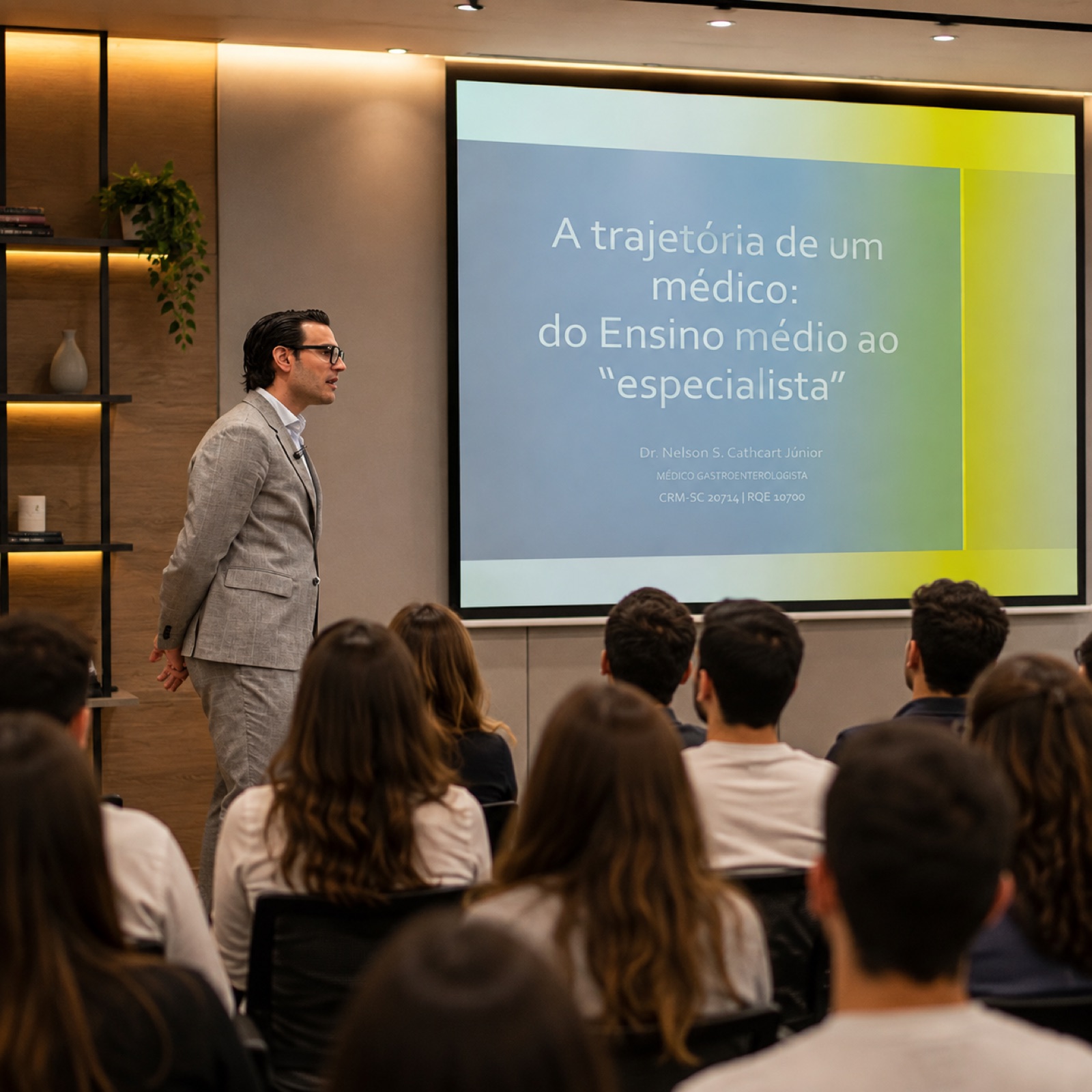 Dr. Nelson Cathcart Jr. dando palestra, ao lado do slide de abertura sobre a trajetória de um médico, com plateia